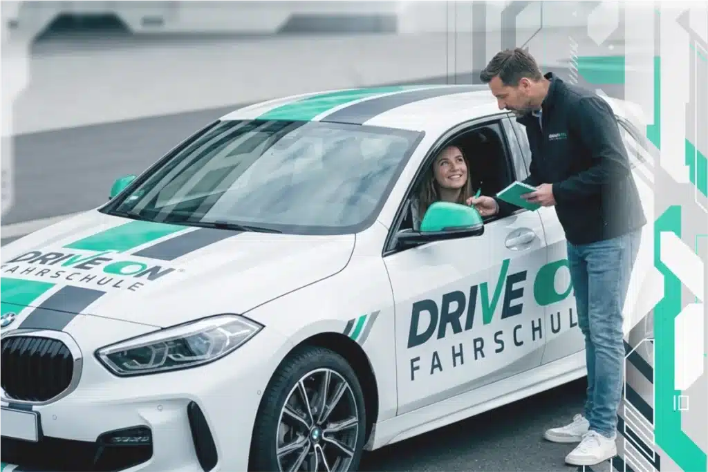 Fahrlehrer erklärt Fahrschülerin die im Fahrschulwagen sitzt etwas